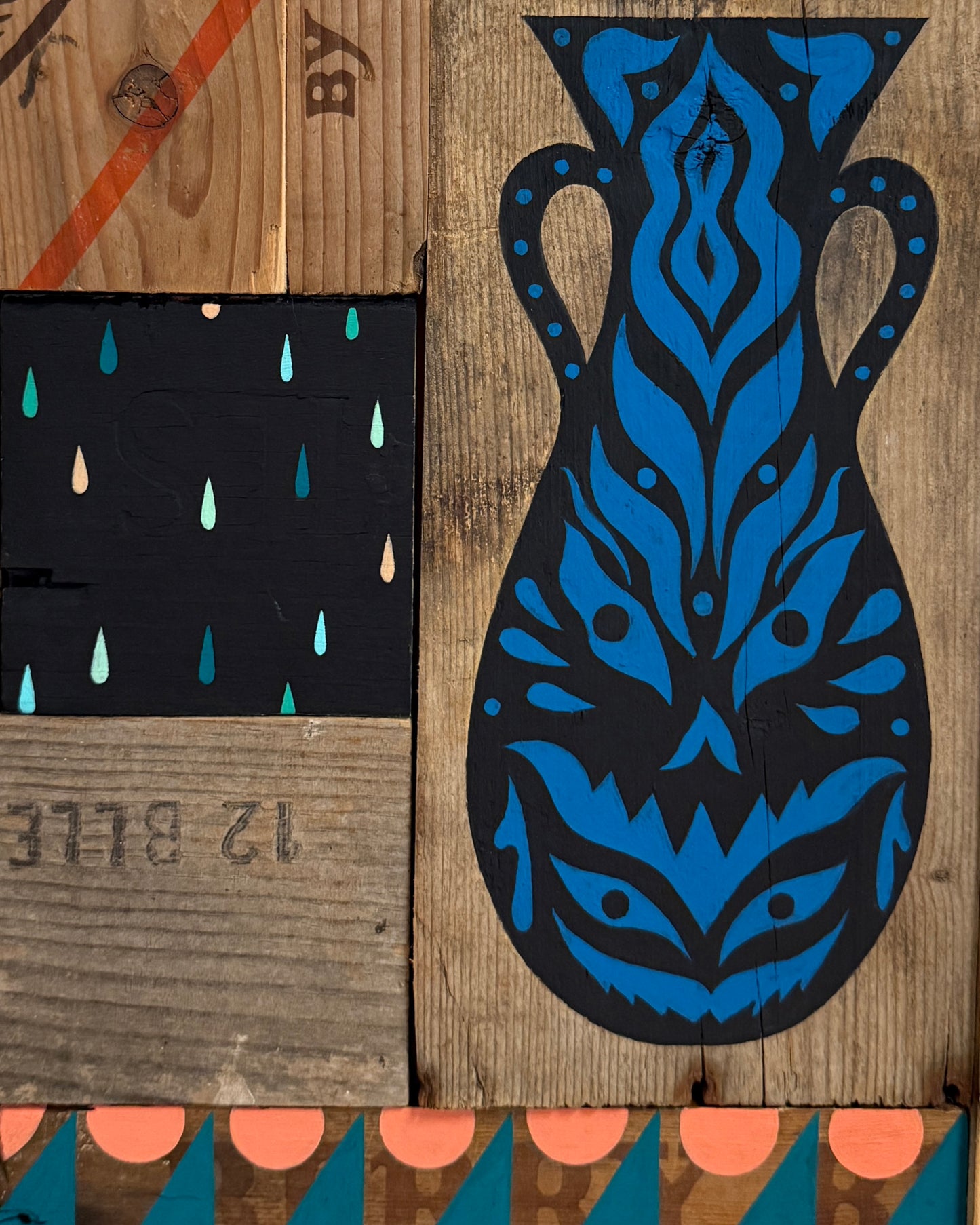 Blue and black decorative mask on a wooden surface with abstract patterns.