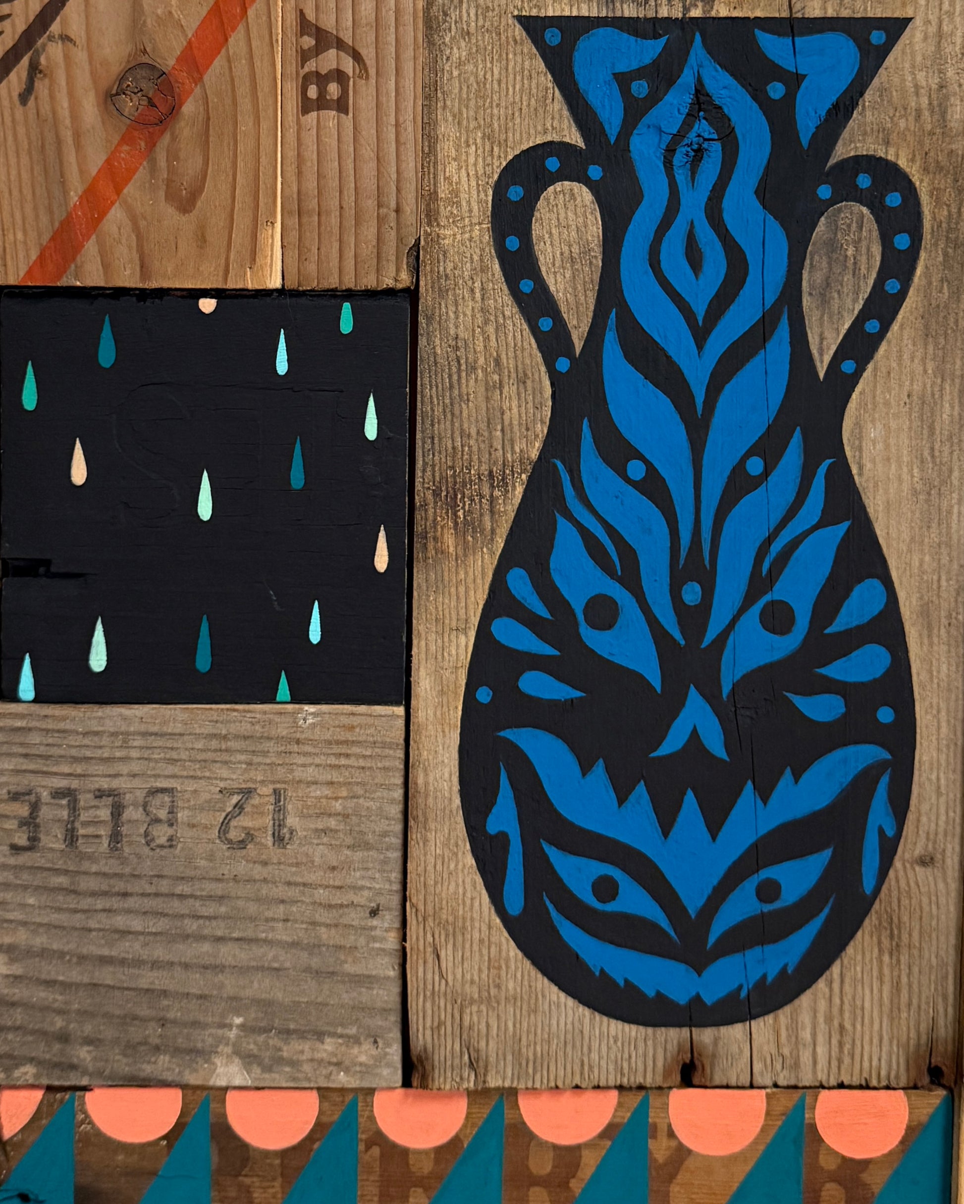 Blue and black decorative mask on a wooden surface with abstract patterns.
