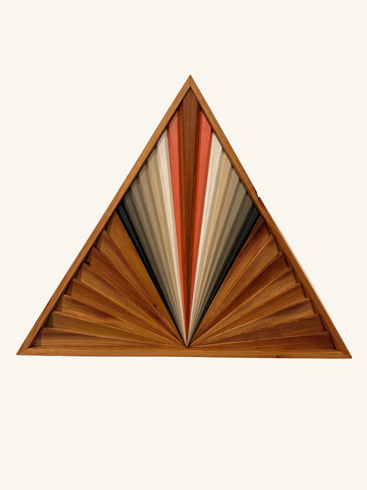 Wooden geometric wall art with a fan-like design on a plain wall.
